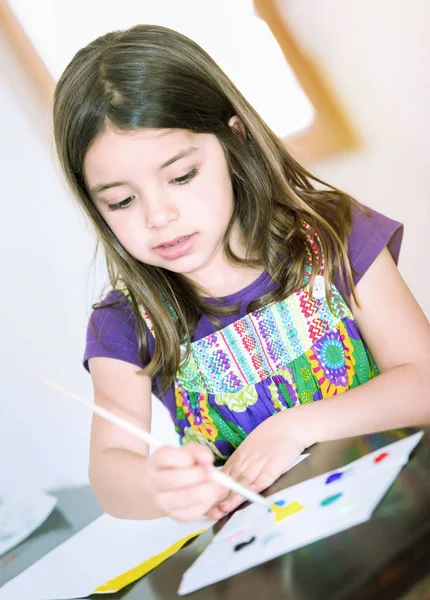 Portret van schattig meisje geconcentreerd tijdens het schilderen — Stockfoto