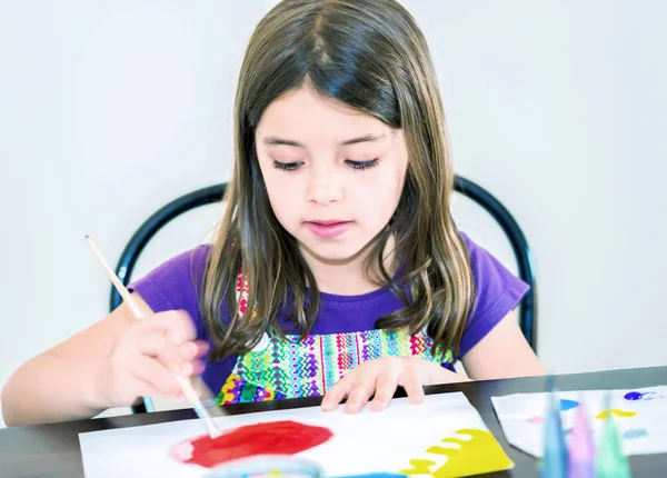 Retrato de menina bonito concentrado enquanto pintura — Fotografia de Stock