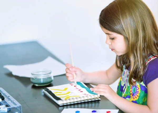 Retrato de menina bonito concentrado enquanto pintura — Fotografia de Stock