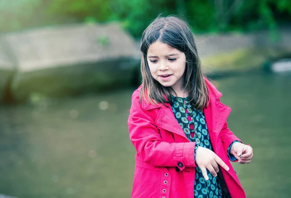 Vrij klein meisje spelen op de rand van het water — Stockfoto