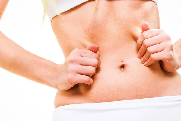 Feminino beliscando pele de sua barriga — Fotografia de Stock