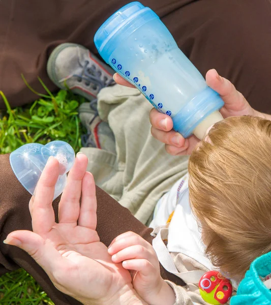 Mère donne à boire de l'eau bébé de la bouteille — Photo