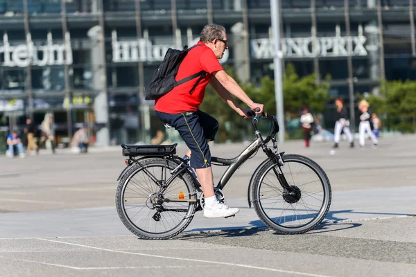 La defense, Francia - 09 de abril de 2014: Hombre en bicicleta en la ciudad. Transporte ecológico limpio alternativo en una ciudad — Foto de Stock