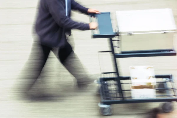 Blurry to view of man transporting merchandise in a street — Stock Photo, Image