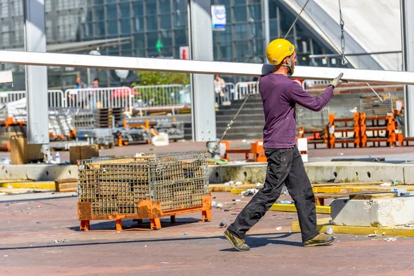 La defense, Frankrike-10 April 2014: byggnadsarbetare bära en stål balk på sina axlar — Stockfoto