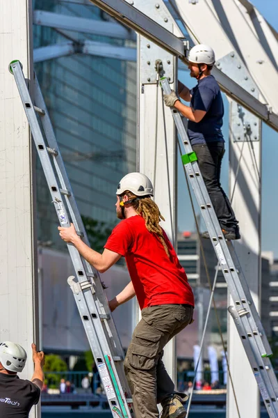 La defense, Francia- 10 de abril de 2014: Dos trabajadores trepan por escaleras metálicas en una obra de construcción — Foto de Stock