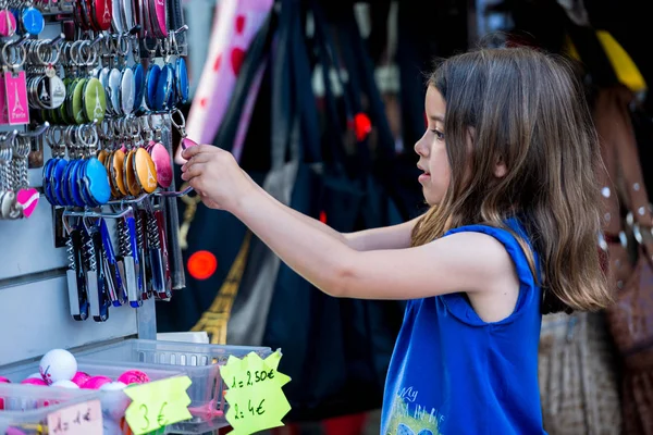 París, Francia 30 de junio de 2013: Kid elige un recuerdo típico de París en una tienda cerca de Montmartre, el lugar más romántico de París — Foto de Stock