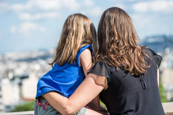 Paris, Frankrijk - 30 juni 2013: moeder en dochter knuffelen hou van kijken naar Parijs vanaf de bovenkant van de heuvel van montmartre — Stockfoto