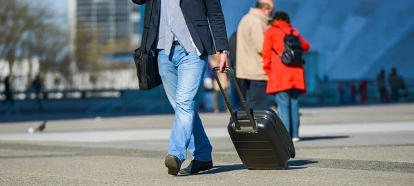 La defense, France- 09 апреля 2014 года: Деловой путешественник, идущий по улице и вытаскивающий чемодан — стоковое фото