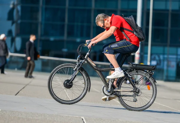 La defense, Francia- Abril 09, 2014: Hombre en bicicleta en la ciudad. Transporte ecológico limpio alternativo en una ciudad — Foto de Stock