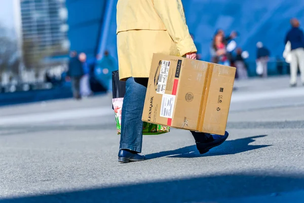 La defense, Francia- Abril 09, 2014: vista lateral del trabajador caminando por una calle con un gran cartón que contiene una impresora que acaba de comprar en una tienda — Foto de Stock