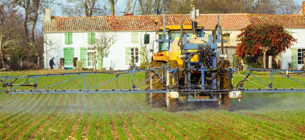 Traktor penyemprotan ladang gandum dengan penyemprot — Stok Foto
