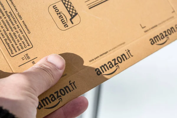 París, Francia - 08 de febrero de 2017: Entrega de un paquete Amazon Prime Parcel frente a la puerta de una casa. Amazon, es una empresa estadounidense de comercio electrónico y computación en nube, con sede en Seattle, Star — Foto de Stock