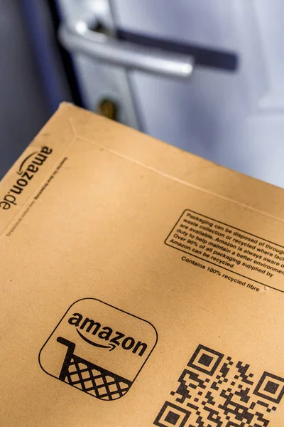 París, Francia - 08 de febrero de 2017: Entrega de un paquete Amazon Prime Parcel frente a la puerta de una casa. Amazon, es una empresa estadounidense de comercio electrónico y computación en nube, con sede en Seattle, Star — Foto de Stock