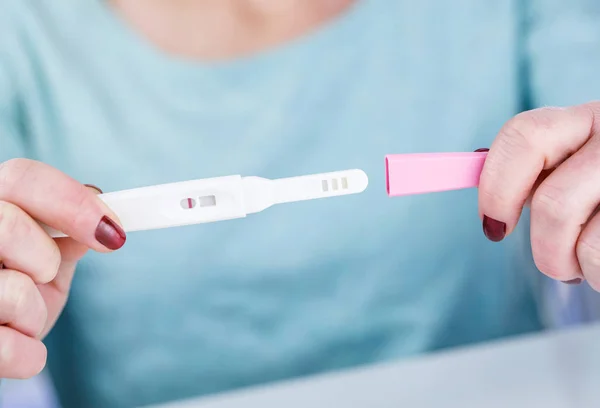 Jovem segurando um teste de gravidez em suas mãos — Fotografia de Stock