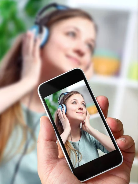 Man taking a picture of his girlfriend with a Smartphone — Stock Photo, Image