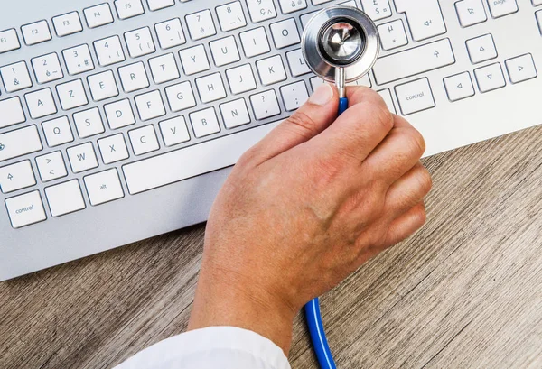 Expert examining a keyboard with stethoscope — Stock Photo, Image