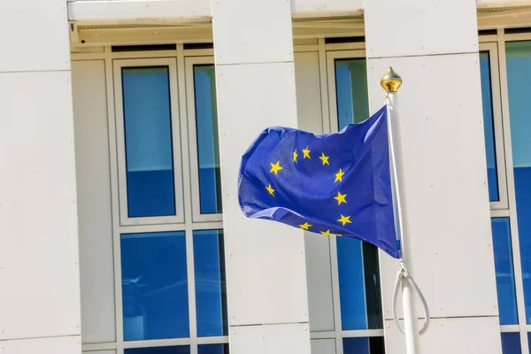 Standard waving flag of the European Union with building business on background — Stock Photo, Image