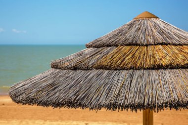 Mavi gökyüzü ile hasır plaj şemsiye