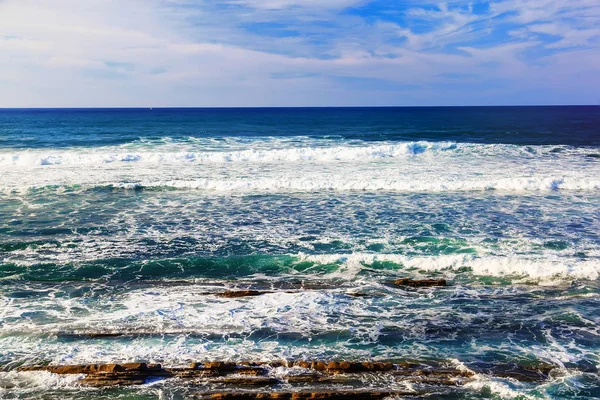 Zeegezicht met rotsen, foam en spray van de golven — Stockfoto