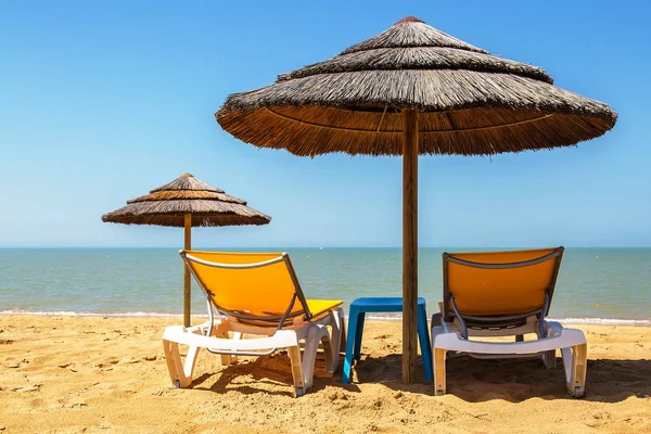 Slunečníků a lehátek na tropické pláži — Stock fotografie