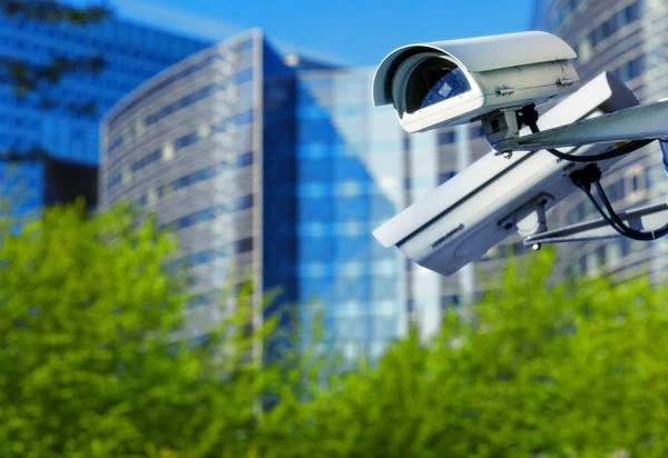 Caméra de sécurité cctv dans une ville avec bâtiment d'affaires blury sur fond — Photo