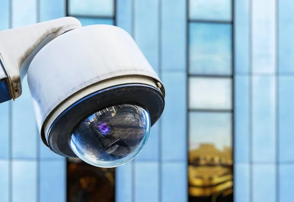 Caméra de sécurité cctv dans une ville avec bâtiment d'affaires blury sur fond — Photo