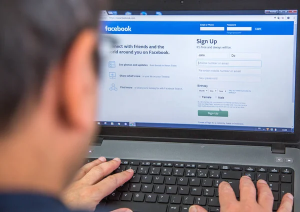 Париж, Франция - 27 января 2017 года: Человек, использующий ноутбук для создания учетной записи пользователя в социальной сети Facebook — стоковое фото