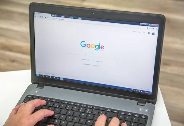 Paris, france - 27. januar 2017: mann benutzt einen laptop und führt eine suche in der suchmaschine google france durch — Stockfoto