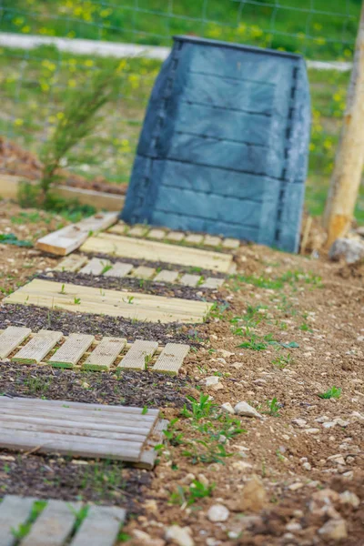 De houten loopbrug plaat met zwarte kunststof compostbak in de tuin van de stad — Stockfoto