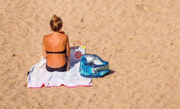 Saint-Jean de Luze, Francia - 28 de septiembre de 2016: vista trasera de una chica increíble tumbada en la playa en la arena, con un bikini negro — Foto de Stock