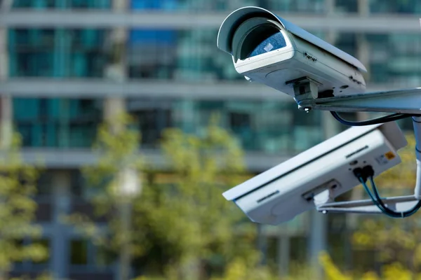 Caméra de sécurité cctv dans une ville avec bâtiment d'affaires blury sur fond — Photo