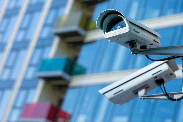 Caméra de sécurité cctv dans une ville avec bâtiment d'affaires blury sur fond — Photo