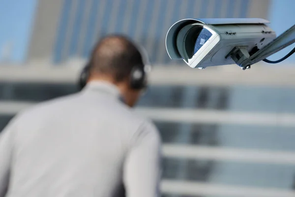 Охоронна камера відеоспостереження або система спостереження з людиною на розмитому фоні — стокове фото