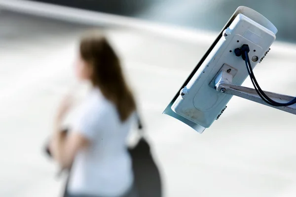 Security CCTV camera or surveillance system with woman on blurry background — Stock Photo, Image