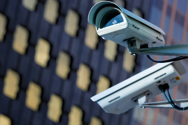 CCTV bewakingscamera in een stad met blury zakelijke gebouw op achtergrond — Stockfoto