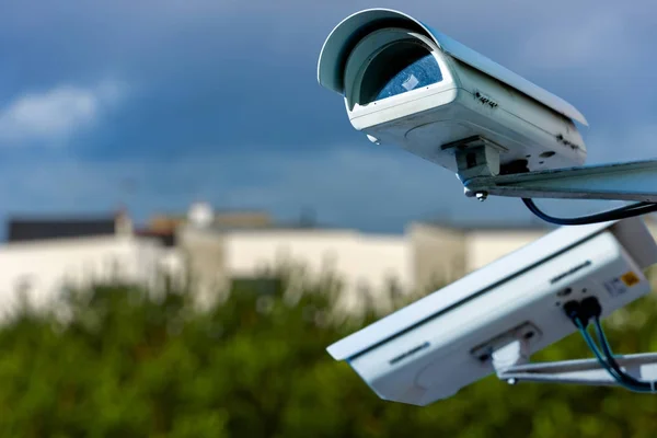 Охоронна камера відеоспостереження або система спостереження з житловими будинками на розмитому фоні — стокове фото