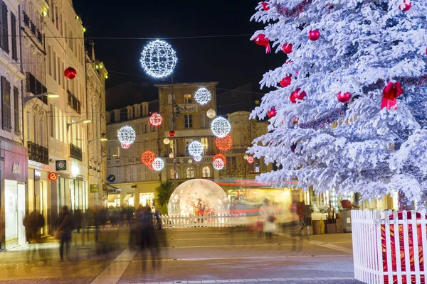 Niort, Francia - 05 dicembre 2017: Primo piano di un albero di Natale innevato con strada illuminata con negozio su entrambi i lati sullo sfondo — Foto Stock