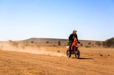 AIT Saoun, Fas - 23 Şubat 2016: Adam sürme quad Bisiklet mavi gökyüzüne karşı Fas AIT Saoun çölde.