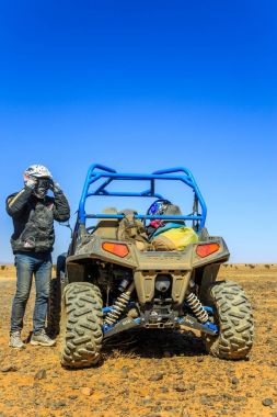 AIT Saoun, Fas - 23 Şubat 2016: adam kumlu çöl boyunca quad bisiklet sürmeyi hazırlanıyor