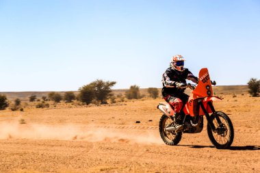 AIT Saoun, Fas - 23 Şubat 2016: Adam sürme quad Bisiklet mavi gökyüzüne karşı Fas AIT Saoun çölde.