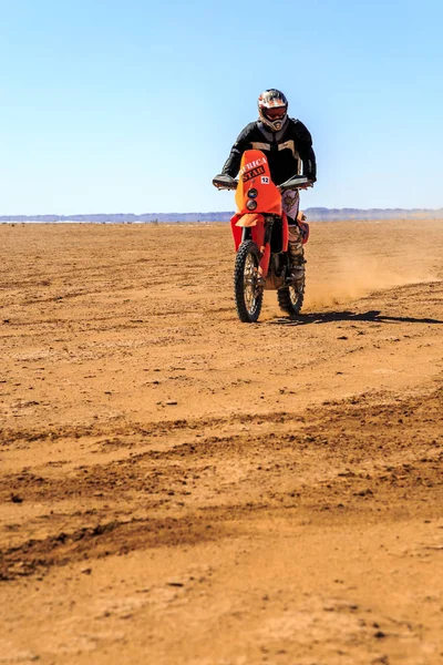 Ait Saoun, Marrocos - 22 de fevereiro de 2016: Homem não identificado de capacete andando de bicicleta no deserto de Ait Saoun, Marrocos . — Fotografia de Stock