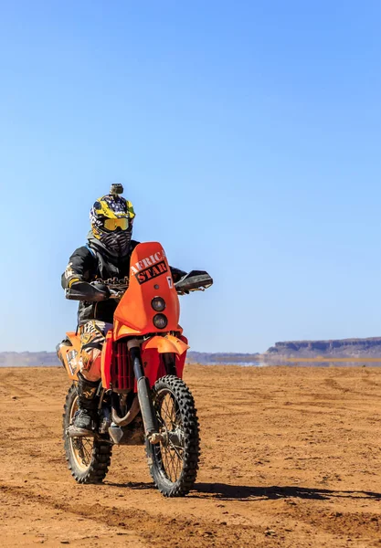 Ait Saoun, Marrocos - 22 de fevereiro de 2016: Homem não identificado de capacete andando de bicicleta no deserto de Ait Saoun, Marrocos . — Fotografia de Stock