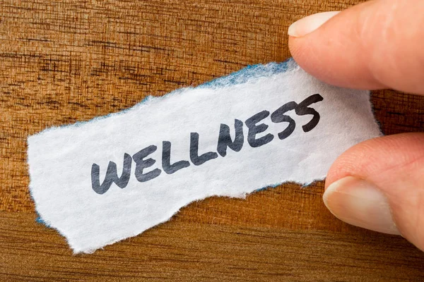 Wellness concept and theme written on old paper on a grunge background — Stock Photo, Image