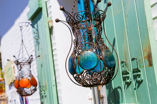 Due lampade in filigrana metallica appese a persiane verdi all'esterno di un edificio bianco . — Foto Stock