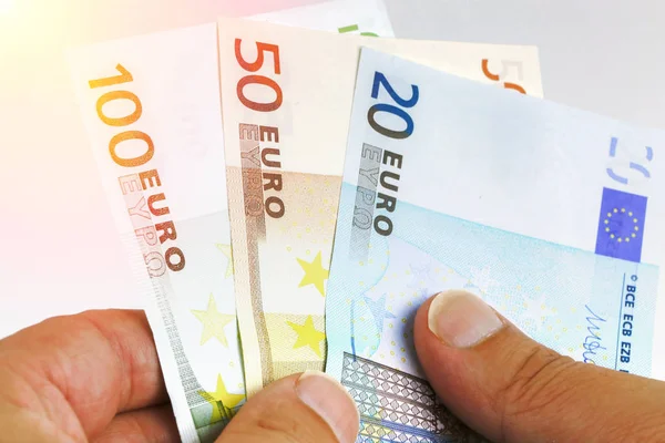 Manos contando billetes de dinero en euros sobre fondo blanco — Foto de Stock