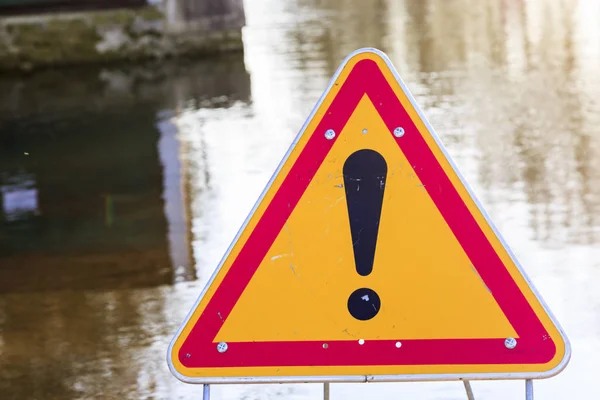 Warning sign of danger in front of a flooded road — Stock Photo, Image