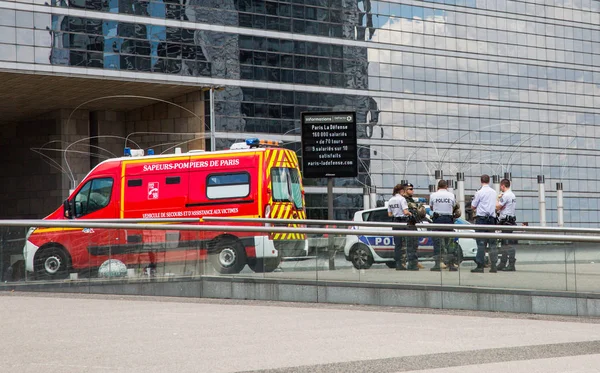 Politieagenten en militairen met een bijeenkomst naast een ambulance — Stockfoto