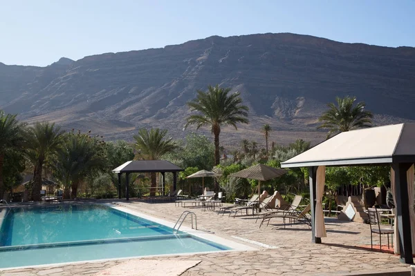 Piscina en una hermosa residencia con palmeras y un fondo montañoso — Foto de Stock