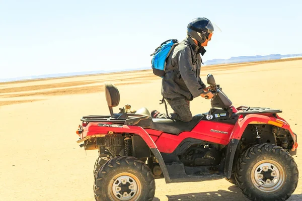 Um piloto numa moto quádrupla no meio do deserto marroquino — Fotografia de Stock